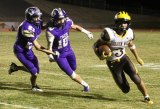 Lemoore players Koy Davis (10) and Julian Ramirez chase down Golden West's Michael Wessel  during Friday night's loss in Tiger Stadium.